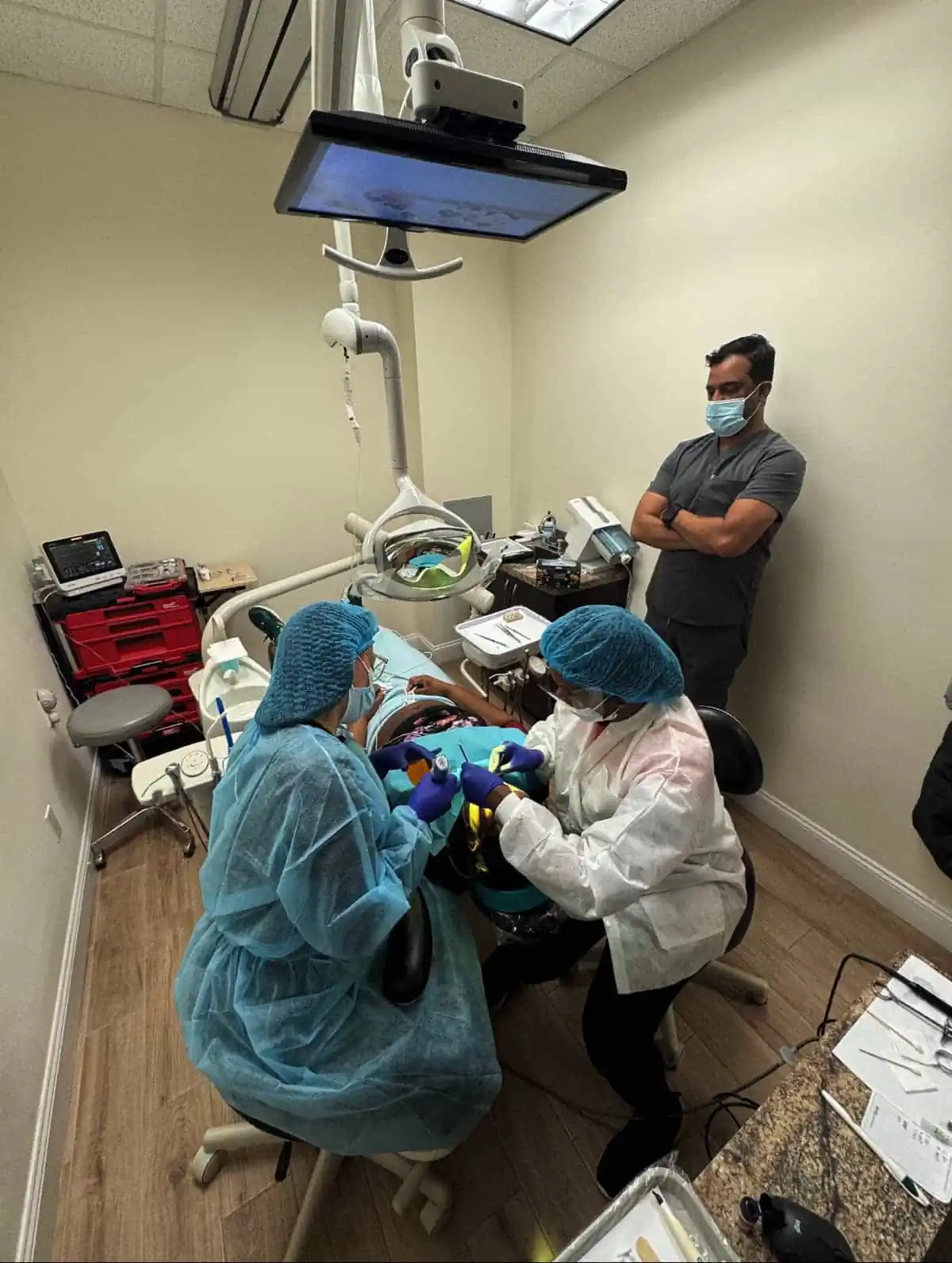 Dentist, anesthesiologist and dental assistant adminstering conscious sedation to a patient at Aesthetic Dental-resized