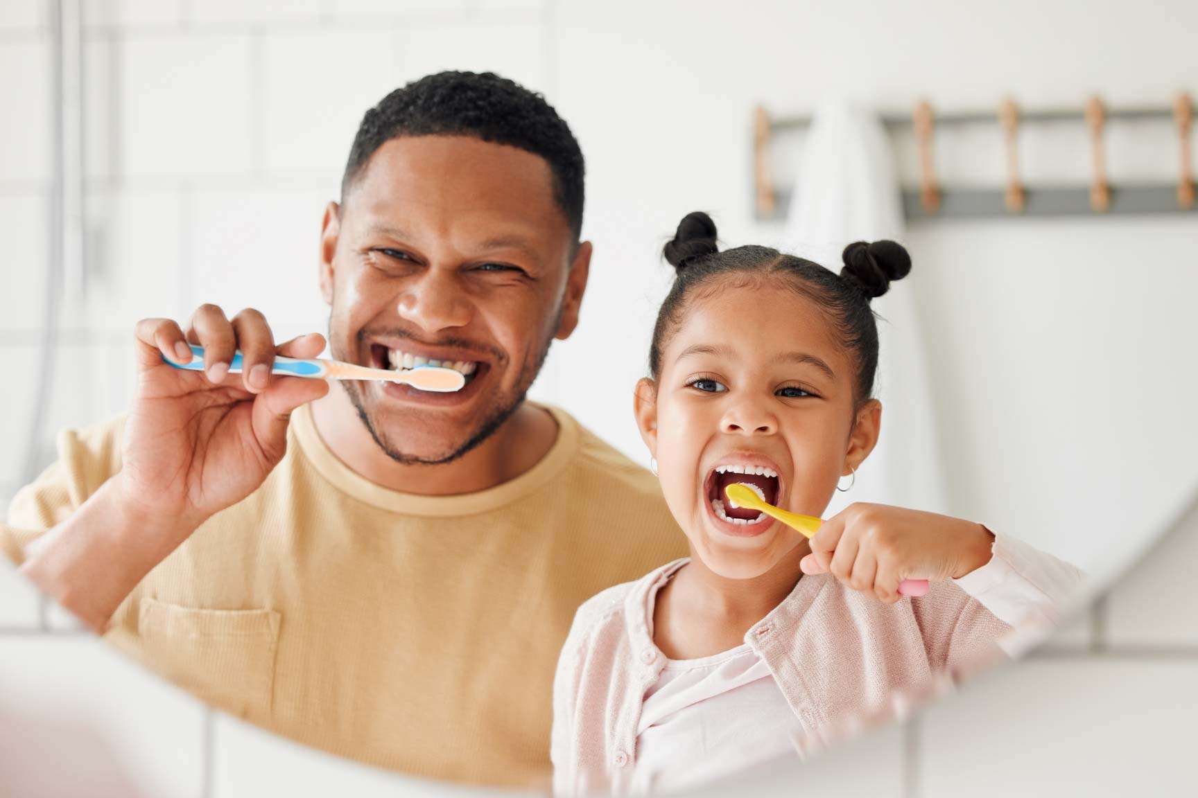 Father and child brushing their teeth together