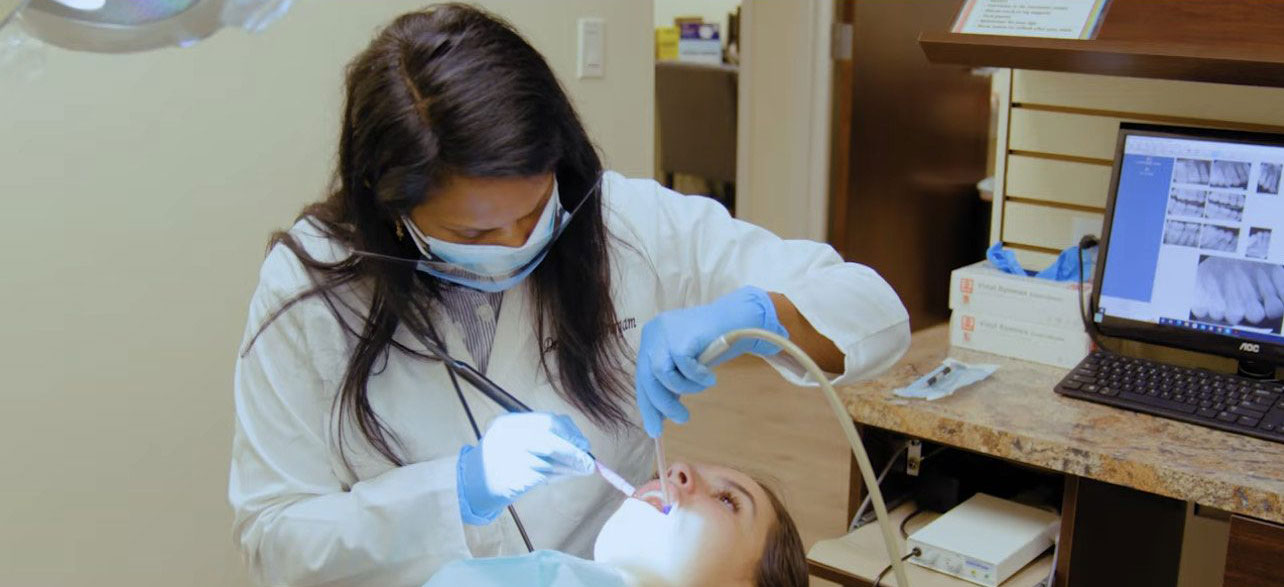 Dr. Durgam using an ultrasonic scaler during periodontal treatment at Aesthetic Dental in North Bergen, NJ.